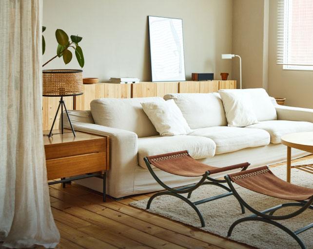 A view of living room with wood floors and a white couch.