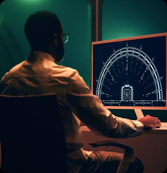 A man working in front of large computer monitor.