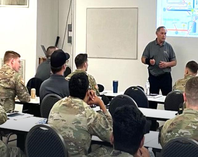 Military personnel are sitting in a classroom listening to a lecture.
