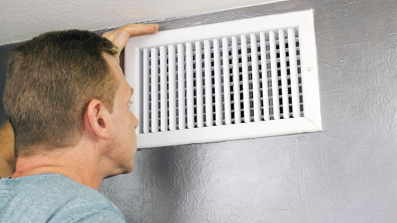 Man smelling air from heat vent