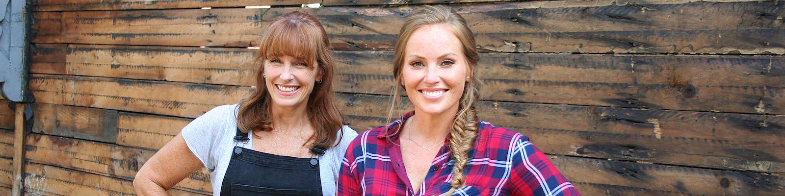 Karen E Laine and Mina Starsiak Hawk of HGTV's Good Bones pose for the camera with their hands on their hips.