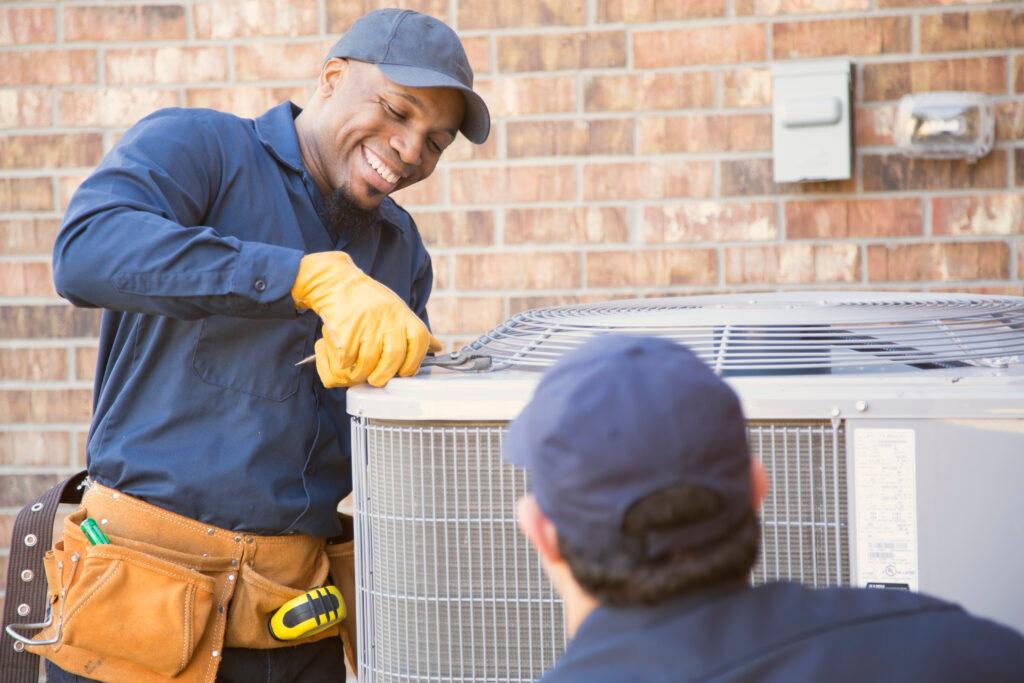 2 HVAC technicians working on an HVAC unit