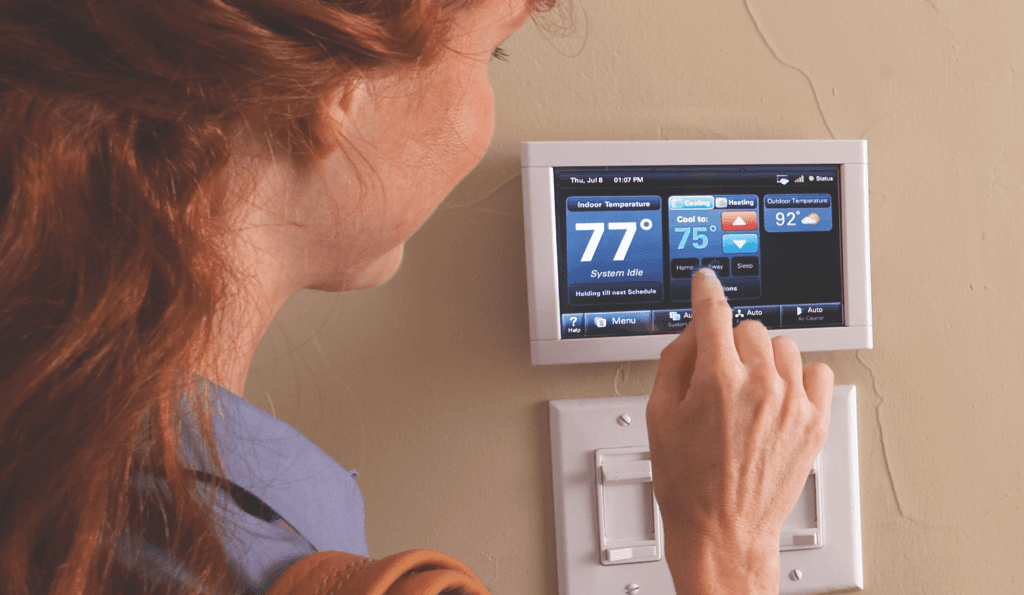 A woman programs her Trane smart thermostat to cool her room down to 75 degrees.