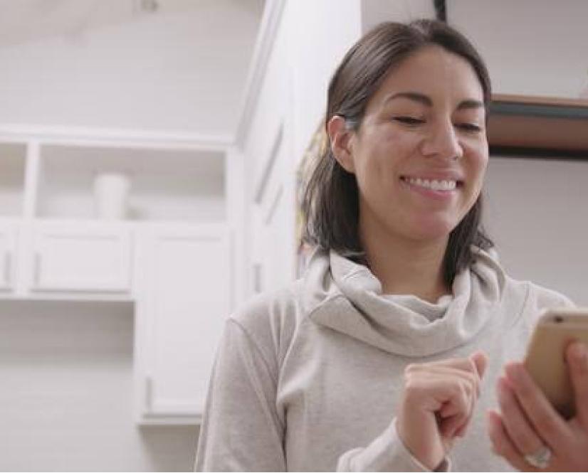 A woman using her smart phone to discover HVAC solutions.