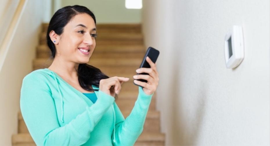 Woman checking thermostat settings.