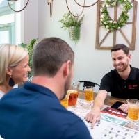 An HVAC dealer talking with customers, pointing at a calendar.