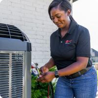 An HVAC dealer working with an outdoor unit.