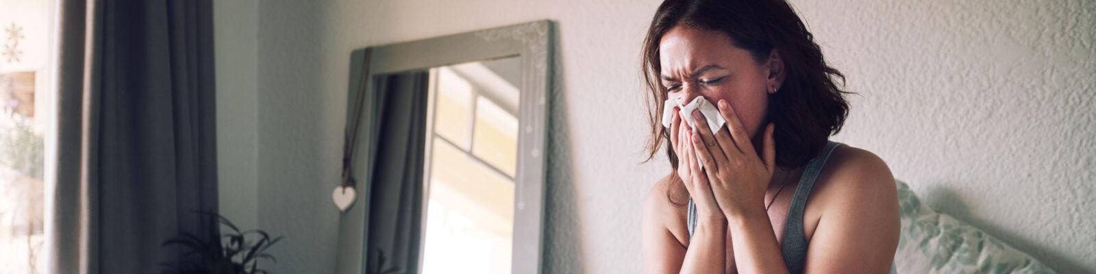 A young woman sick in bed during flu season.