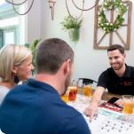 An HVAC dealer working with customers in their living room.