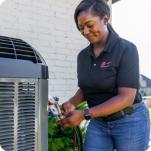 HVAC technician inspecting outdoor unit.