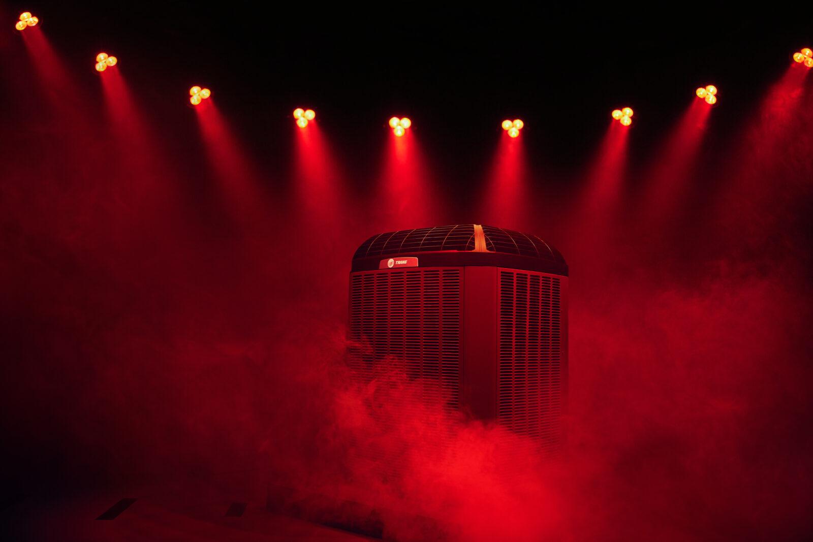 A home HVAC air unit is sitting in a cloud of red steam.