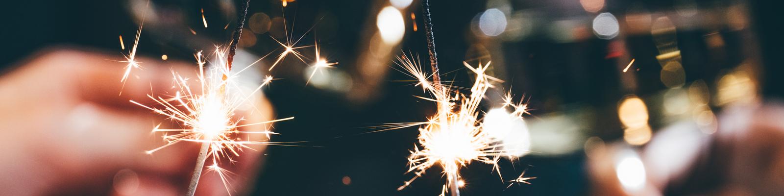 Close-up of human hands holding sparklers.