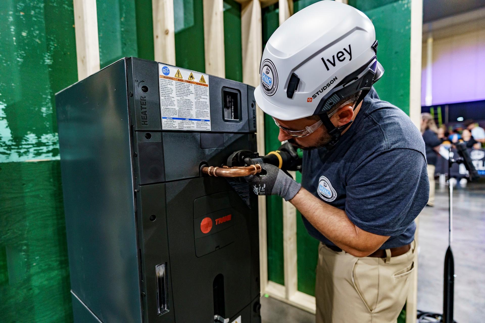 An HVAC technician is working on a Trane air handler.
