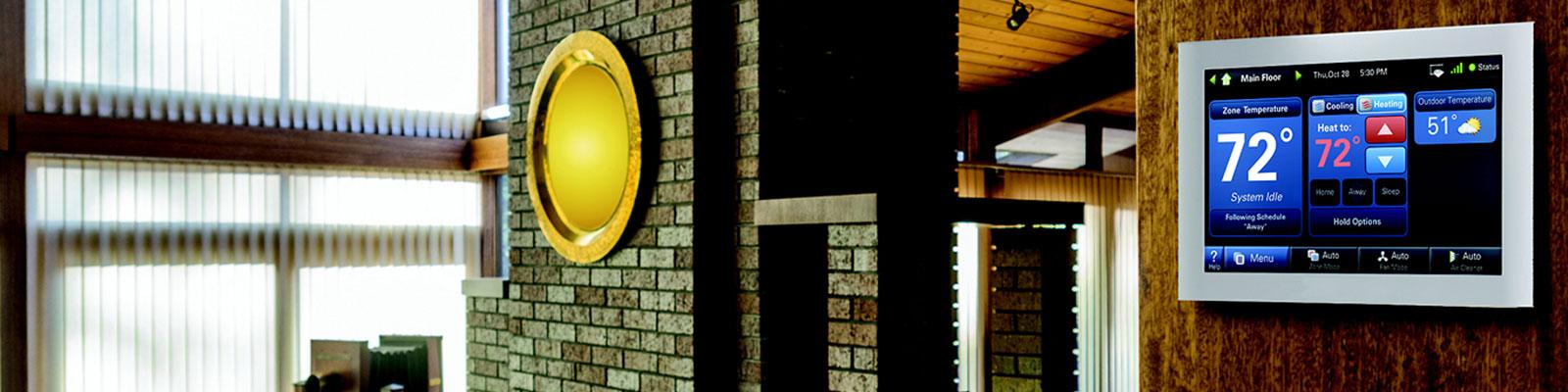 A thermostat is on a home wall near a fireplace.