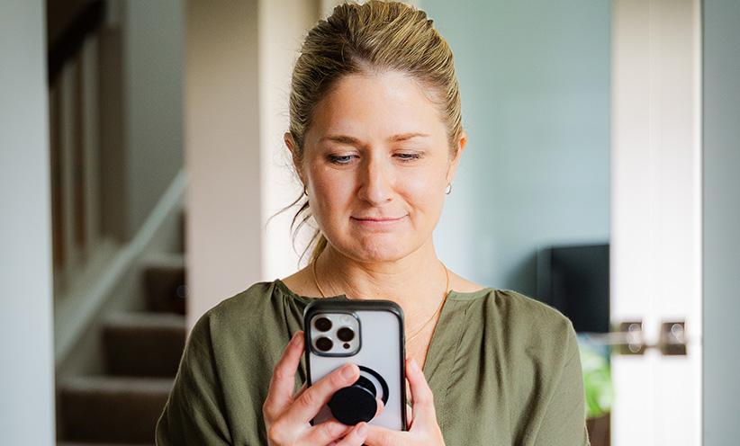 A female homeowner is looking at her phone.