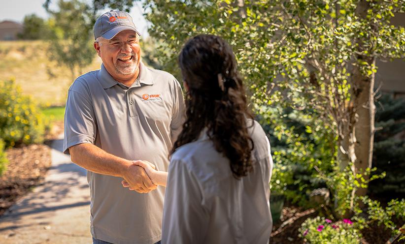 An HVAC Performance Monitoring dealer shakes hands with a new client.