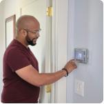 A man is setting his smart thermostat.