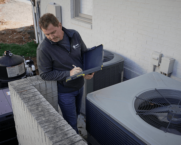 Trane technician examines a gas furnace.