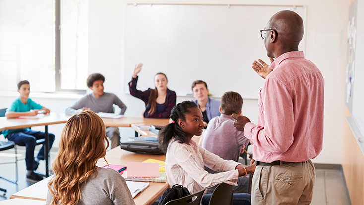 Teacher leading a classroom discussion with high school students
