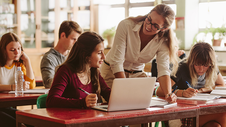 Teacher assisting a student with a classroom activity