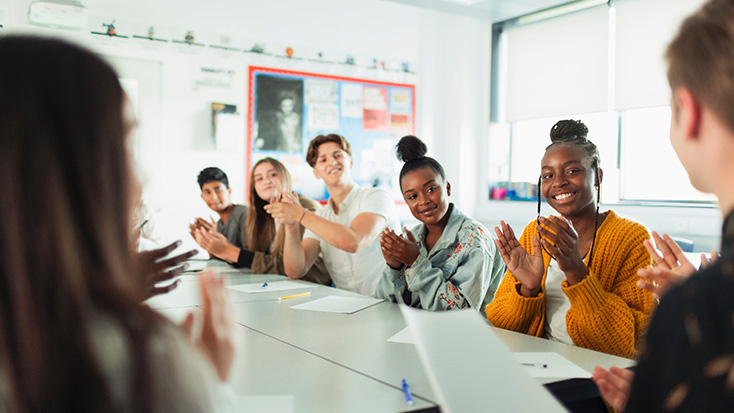 High school students applauding during in a classroom activity