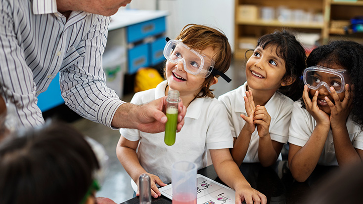 Elementary school students wearing safety goggles during a classroom science experiment