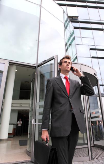 Businessman in front of building talking on the phone