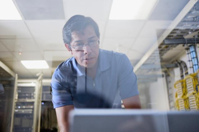 Man working on computer in data center