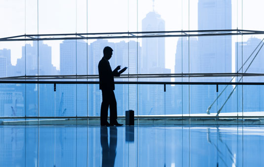 Silhouette of man against building windows