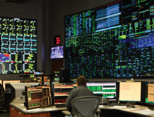 man monitoring data on multiple screens