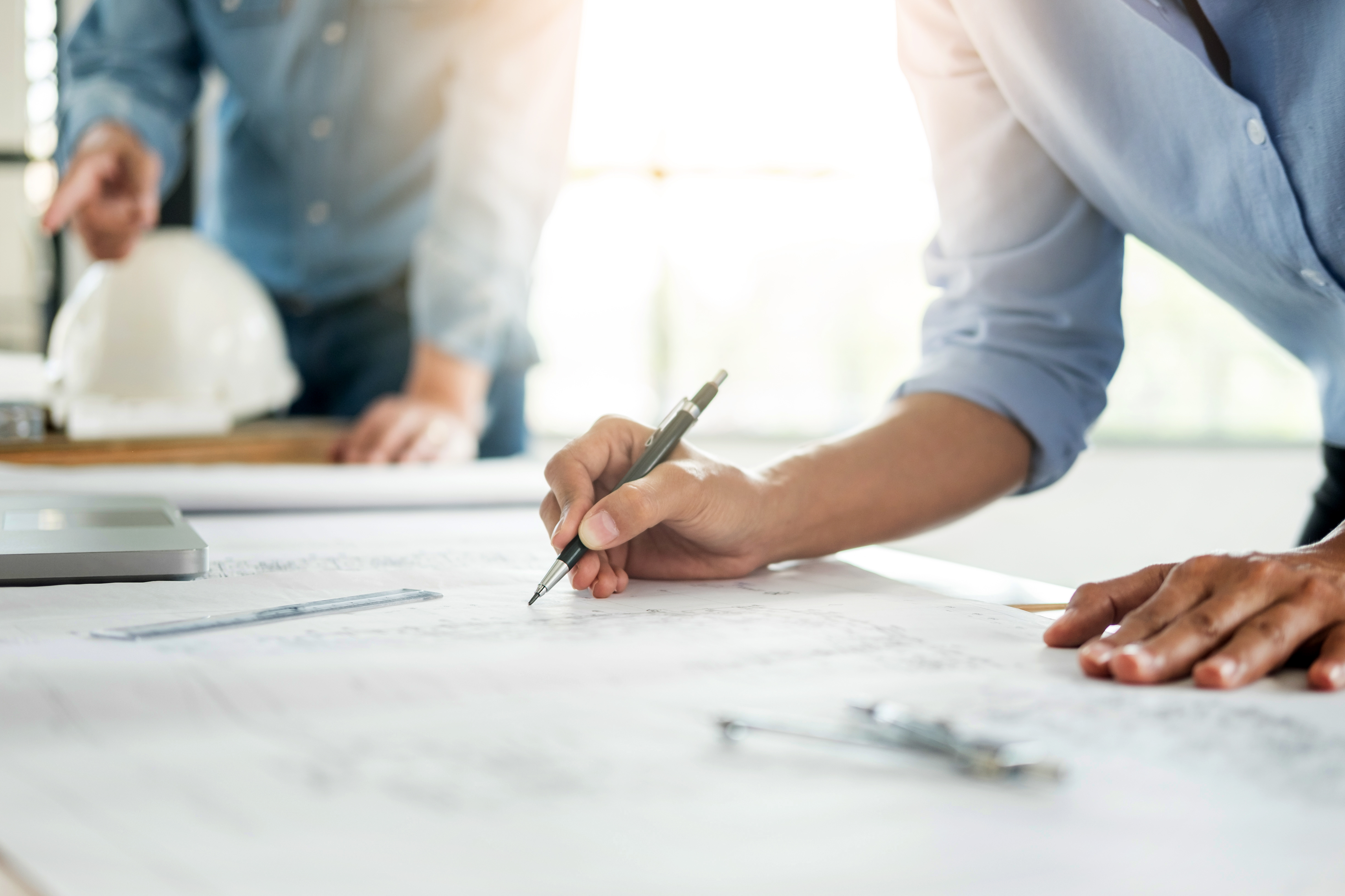 Close-up Of Person's engineer Hand Drawing Plan On Blue Print with architect equipment, Architects discussing at the table, team work and work flow construction concept