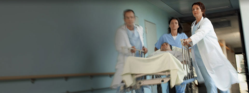 Hospital workers rushing down hall with patient